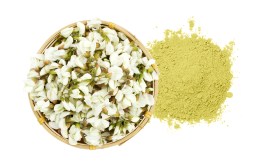 a bowl of flowers next to a pile of powder